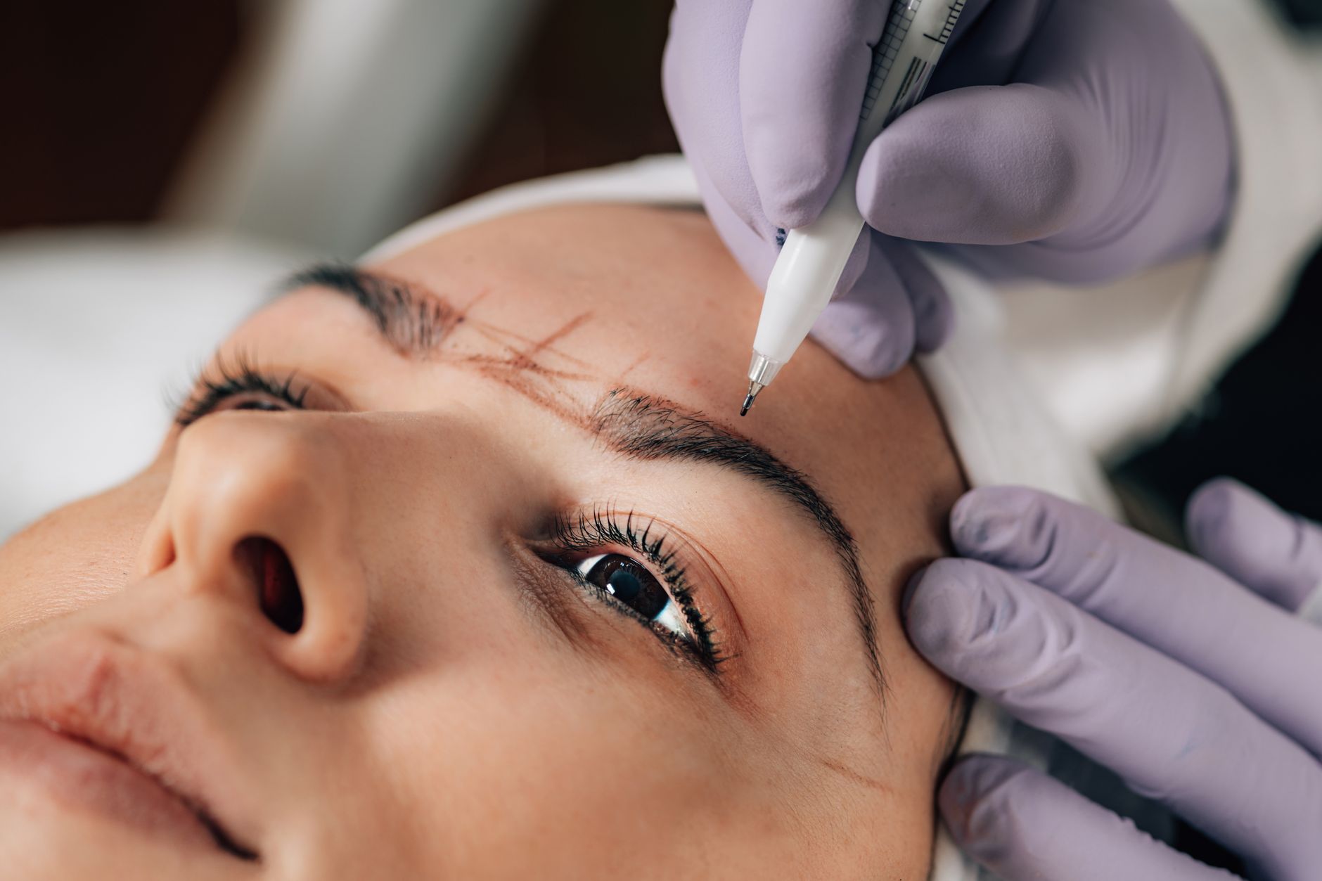 Close-up of a semi-permanent eyebrow makeup procedure being applied to a client